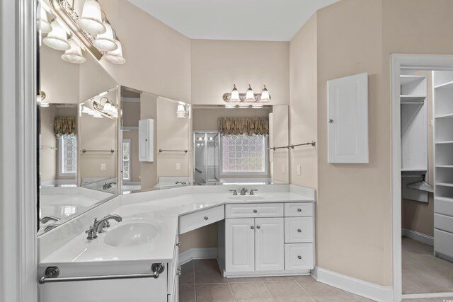 full bath with tile patterned floors, double vanity, and baseboards