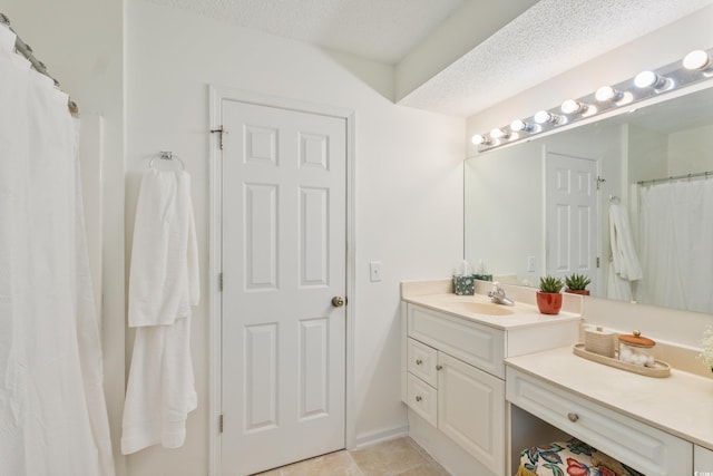 full bath featuring vanity, tile patterned floors, and a textured ceiling