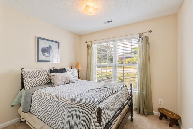 bedroom with carpet floors, baseboards, and a textured ceiling