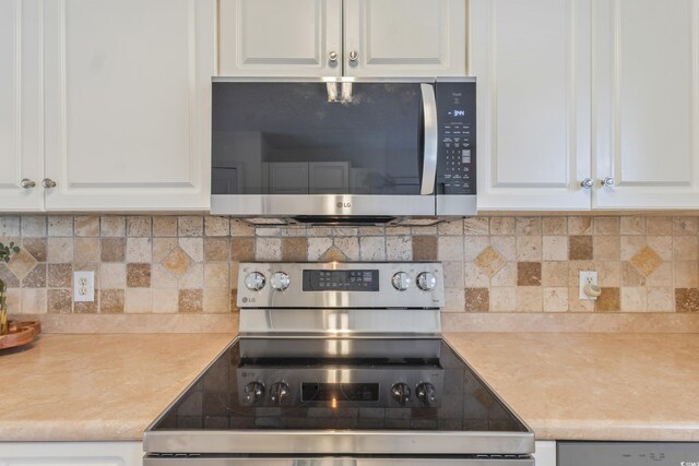 kitchen with stainless steel appliances, light countertops, white cabinets, and tasteful backsplash