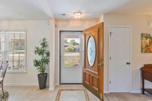 entryway featuring healthy amount of natural light, a textured ceiling, and baseboards