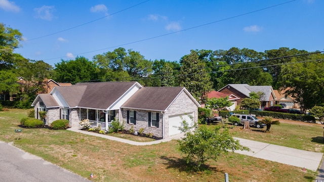single story home with a porch, a front yard, a garage, stone siding, and concrete driveway