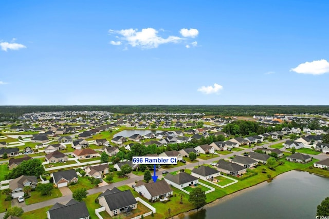 aerial view of property and surrounding area featuring nearby suburban area and a nearby body of water