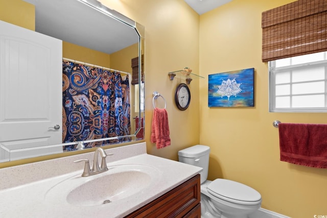 bathroom with toilet, vanity, and curtained shower