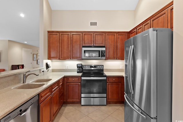 kitchen featuring appliances with stainless steel finishes, a sink, light tile patterned floors, light countertops, and recessed lighting