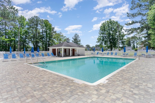 community pool with fence and a patio
