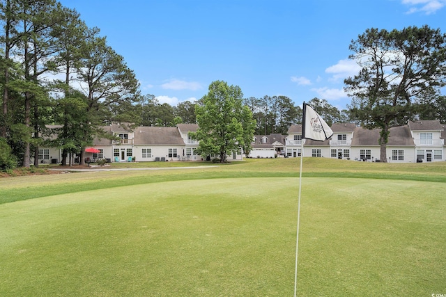 surrounding community with golf course view, a lawn, and a residential view