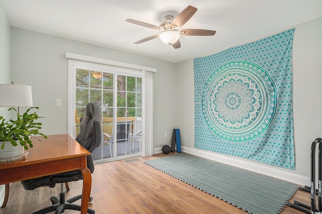 home office with wood finished floors, ceiling fan, and baseboards