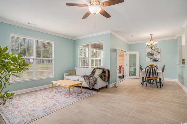 living room with a chandelier, baseboards, crown molding, light wood finished floors, and a ceiling fan
