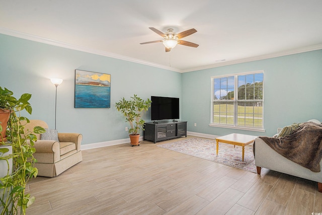 living room featuring light wood finished floors, ceiling fan, baseboards, and ornamental molding