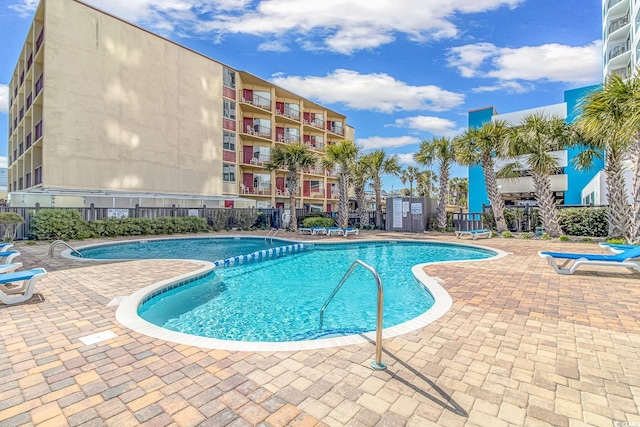 community pool featuring a patio and fence