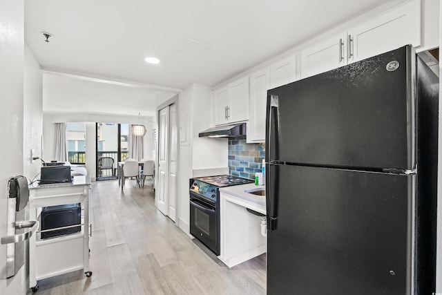 2401 S Ocean Blvd Unit 351, Myrtle Beach, SC 29577 - kitchen with black appliances, under cabinet range hood, white cabinets, decorative backsplash, and light wood finished floors