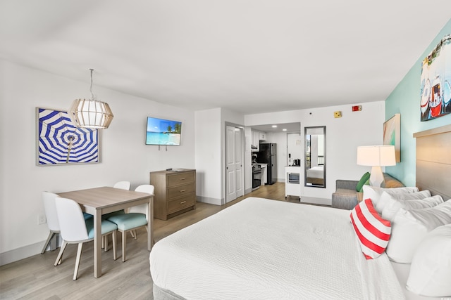 2401 S Ocean Blvd Unit 351, Myrtle Beach, SC 29577 - bedroom featuring light wood-style floors, freestanding refrigerator, and baseboards