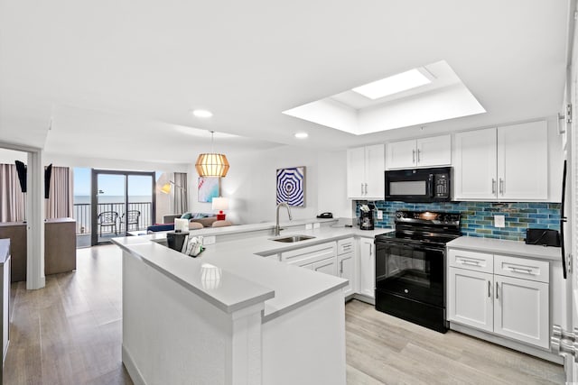 2301 S Ocean Blvd Unit 621, Myrtle Beach, SC 29577 - kitchen featuring black appliances, a sink, a peninsula, light wood finished floors, and tasteful backsplash