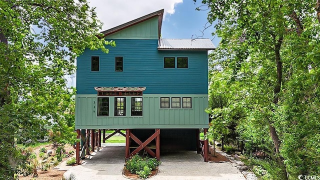 view of front facade featuring a carport, driveway, and board and batten siding