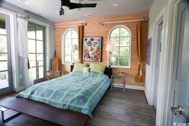 bedroom featuring baseboards, wood finished floors, ceiling fan, and access to exterior