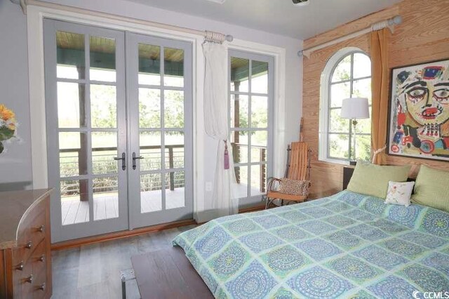 bedroom with wood finished floors, access to outside, and french doors