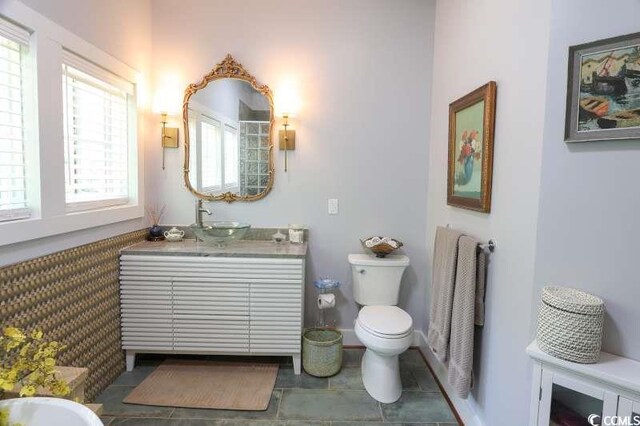 full bathroom with toilet, tile patterned floors, and vanity