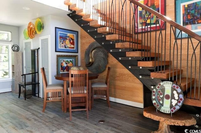 dining area featuring wood finished floors, stairway, and baseboards