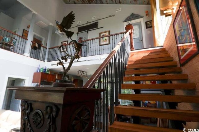 stairway featuring a towering ceiling