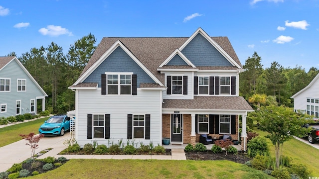1325 Bermuda Grass Dr, Myrtle Beach, SC 29579 - view of front facade featuring a porch, a front lawn, roof with shingles, and driveway