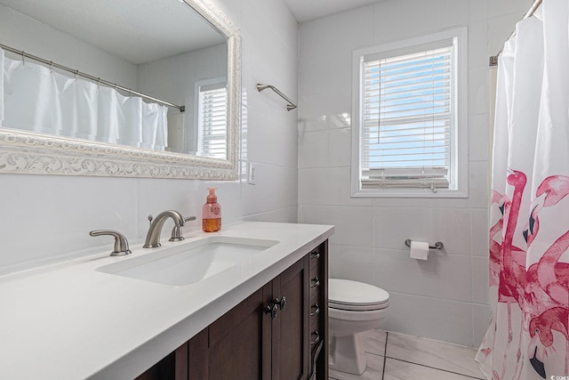 full bath with toilet, vanity, tile walls, and a shower with curtain
