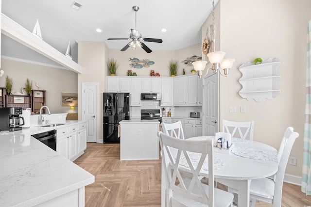 kitchen with black appliances, a sink, a center island, a ceiling fan, and white cabinets