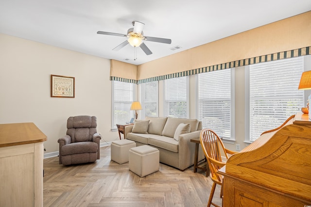 living room featuring plenty of natural light, ceiling fan, and baseboards
