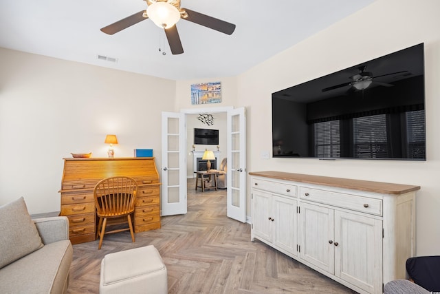 living area with french doors and a ceiling fan