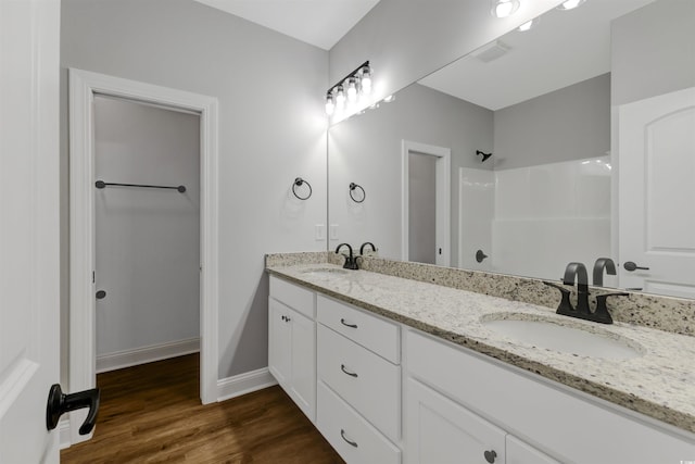 4120 Whatuthink Rd, Myrtle Beach, SC 29588 - bathroom featuring a shower, wood finished floors, double vanity, and baseboards