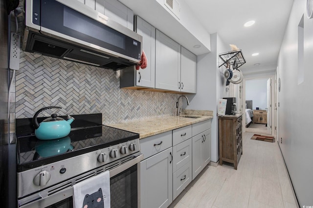 9400 Shore Dr Unit 509, Myrtle Beach, SC 29572 - kitchen with stainless steel appliances, a sink, backsplash, light stone countertops, and recessed lighting