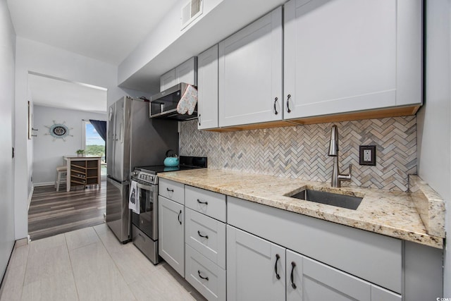 9400 Shore Dr Unit 509, Myrtle Beach, SC 29572 - kitchen featuring stainless steel appliances, a sink, tasteful backsplash, and light stone countertops