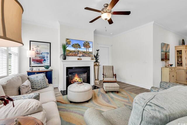 1340 Jolly Roger Dr, North Myrtle Beach, SC 29582 - living area featuring wood finished floors, ceiling fan, ornamental molding, baseboards, and a glass covered fireplace