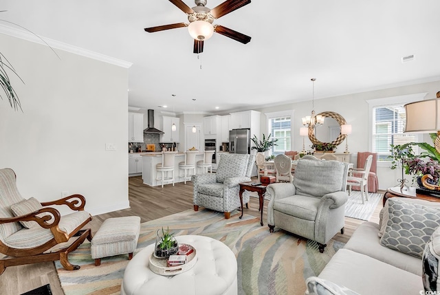 1340 Jolly Roger Dr, North Myrtle Beach, SC 29582 - living area with plenty of natural light, a ceiling fan, light wood-type flooring, a chandelier, and crown molding