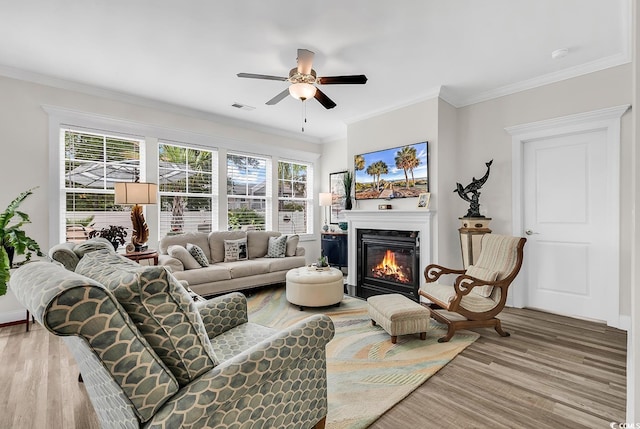 1340 Jolly Roger Dr, North Myrtle Beach, SC 29582 - living area featuring a glass covered fireplace, light wood-type flooring, ceiling fan, crown molding, and baseboards