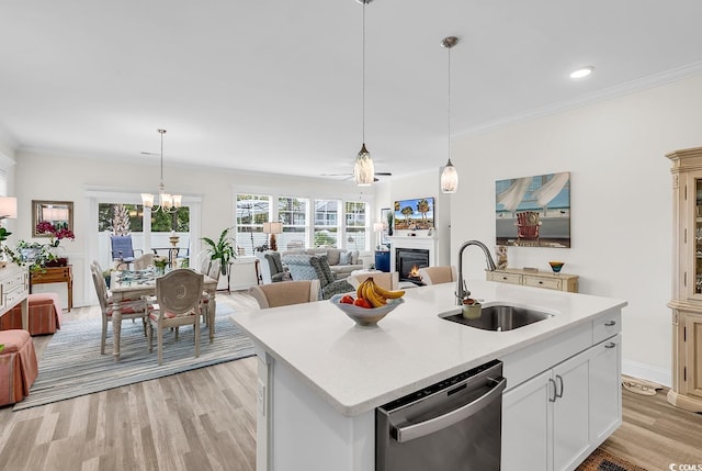 1340 Jolly Roger Dr, North Myrtle Beach, SC 29582 - kitchen featuring a sink, stainless steel dishwasher, light wood-style floors, a warm lit fireplace, and open floor plan
