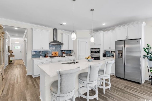 1340 Jolly Roger Dr, North Myrtle Beach, SC 29582 - kitchen with appliances with stainless steel finishes, wall chimney range hood, a sink, a breakfast bar, and backsplash
