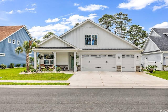 1340 Jolly Roger Dr, North Myrtle Beach, SC 29582 - view of front of home with board and batten siding, concrete driveway, a front yard, and stone siding