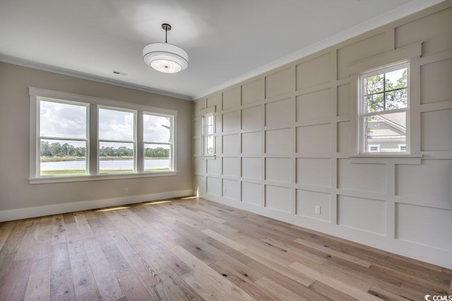 1142 Fiddlehead Way, Myrtle Beach, SC 29579 - spare room featuring a decorative wall, crown molding, light wood-style floors, baseboards, and a water view