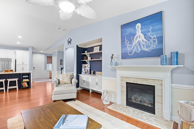 1444 Thames Ct, Myrtle Beach, SC 29577 - living area featuring vaulted ceiling, ceiling fan, wood finished floors, a brick fireplace, and recessed lighting