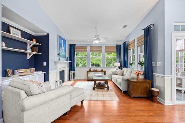1444 Thames Ct, Myrtle Beach, SC 29577 - living area featuring plenty of natural light, a ceiling fan, light wood-type flooring, vaulted ceiling, and a glass covered fireplace
