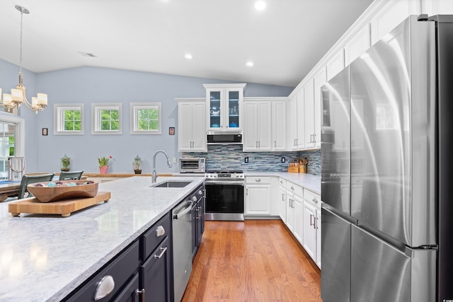 1444 Thames Ct, Myrtle Beach, SC 29577 - kitchen with stainless steel appliances, a sink, vaulted ceiling, white cabinets, and light wood finished floors