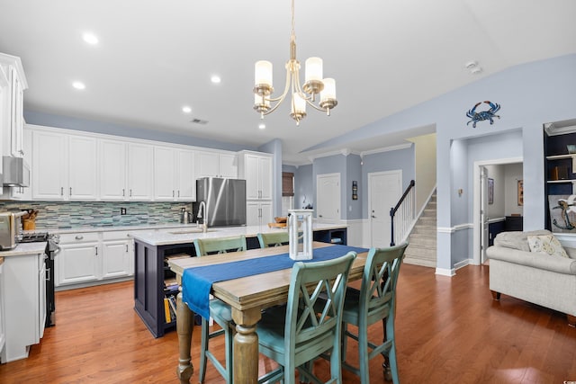 1444 Thames Ct, Myrtle Beach, SC 29577 - kitchen with appliances with stainless steel finishes, white cabinetry, an island with sink, vaulted ceiling, and backsplash