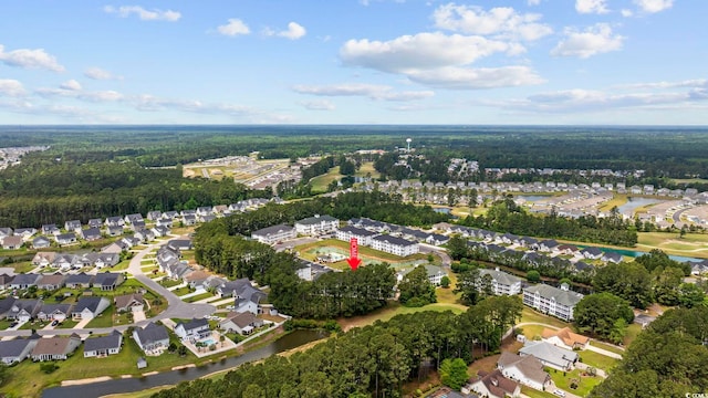 aerial view of property's location featuring nearby suburban area and a heavily wooded area