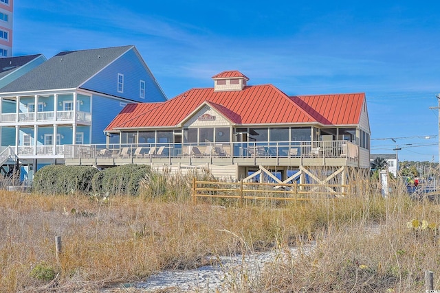 4803 Bucks Bluff Dr, North Myrtle Beach, SC 29582 - rear view of house with metal roof and a sunroom