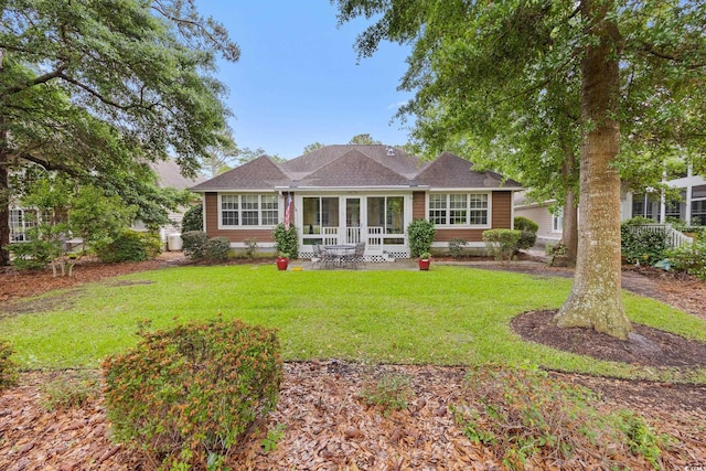 4803 Bucks Bluff Dr, North Myrtle Beach, SC 29582 - view of front facade with a front lawn, a sunroom, and a shingled roof