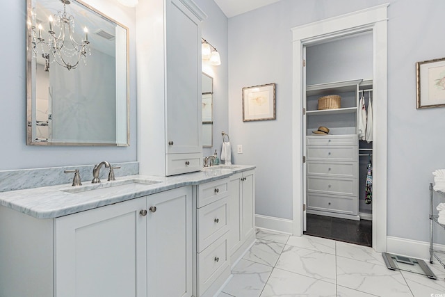 5032 Middleton View Dr, Myrtle Beach, SC 29579 - bathroom featuring baseboards, marble look tiles, double vanity, a spacious closet, and a chandelier
