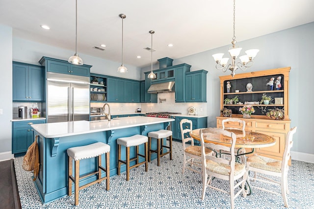 5032 Middleton View Dr, Myrtle Beach, SC 29579 - kitchen featuring open shelves, built in refrigerator, under cabinet range hood, a chandelier, and blue cabinets