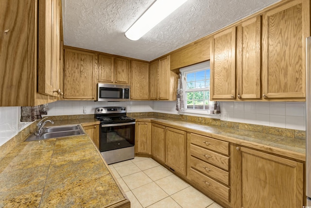 2519 Reta St, Conway, SC 29526 - kitchen featuring stainless steel appliances, a sink, tile counters, tasteful backsplash, and a textured ceiling