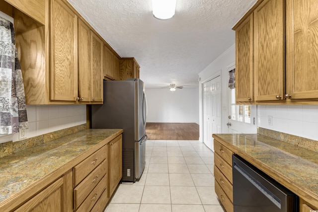 kitchen with dishwashing machine, a textured ceiling, freestanding refrigerator, tasteful backsplash, and brown cabinetry